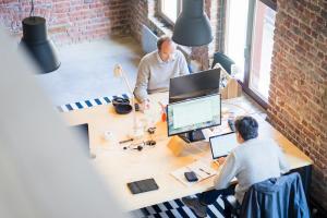 Coworkers on their computers at their desks in an office.